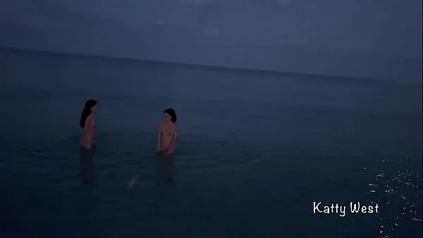 Two naked sluts play with each other in the sea on a public beach